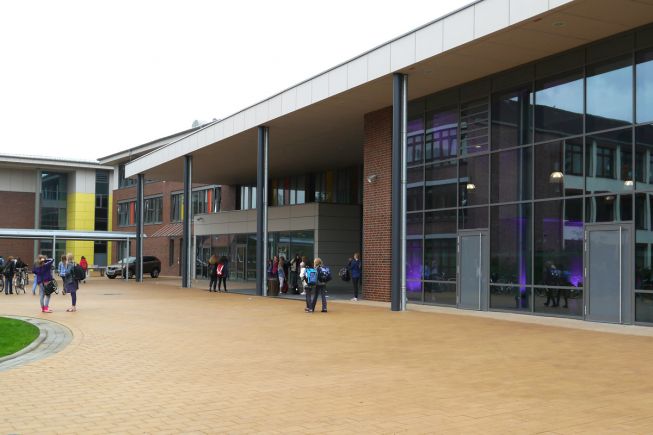 Die Aula im Bildvordergrund und die links daneben liegende Mensa liegen im Zentrum des Schulkomplexes und prägen die Ansicht vom Schulhof (Alle Bilder: VBD).